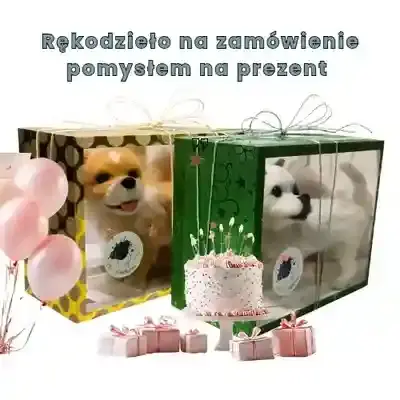 Dwa pudełka prezentowe z figurkami szydełkowych piesków ozdobione balonami i tortem.